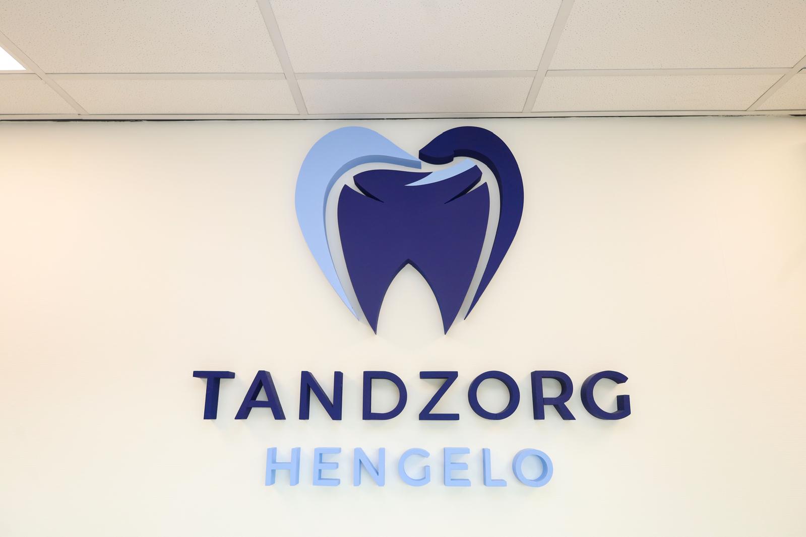 Het logo van Tandzorg Hengelo aan de wand in de praktijk